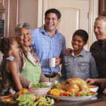 Diverse family in home kitchen cooking Thanksgiving dinner.