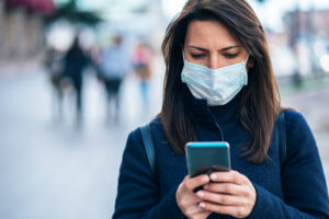 Woman with face protective mask using phone