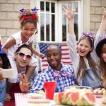 families in red white and blue around picnic table