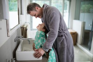 Dad and son at bathroom sink